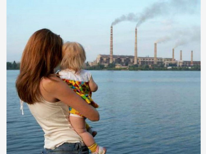 Женщина с ребёнком на фоне плохой экологии