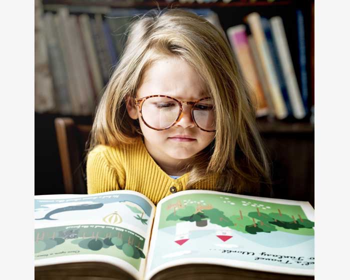 Девочка в очках читает книгу