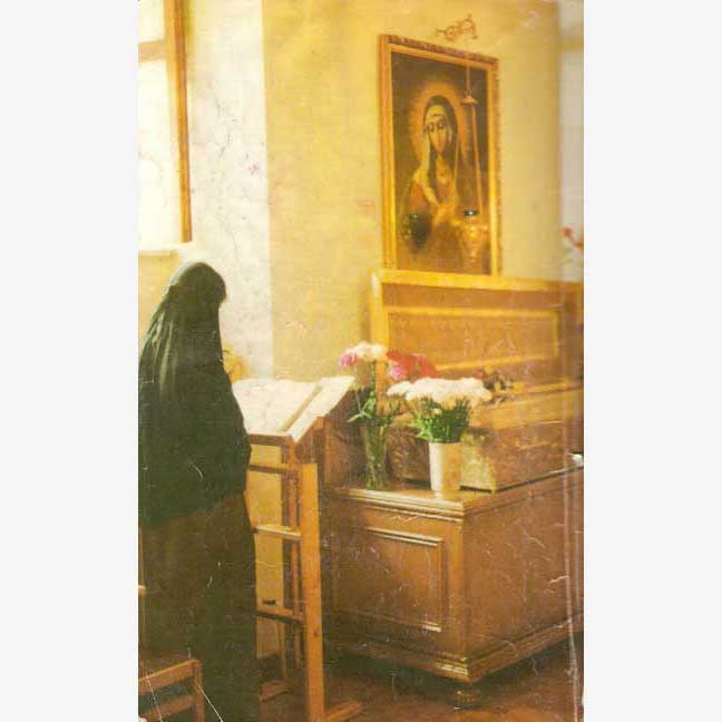 Женщина молится перед иконой Матроны Московской
