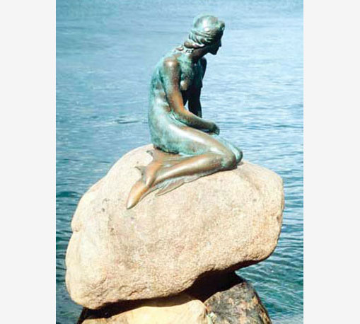 Статуя русалки изображает её сидящей на камне
