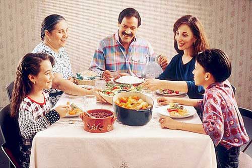 Семья обедает за столом