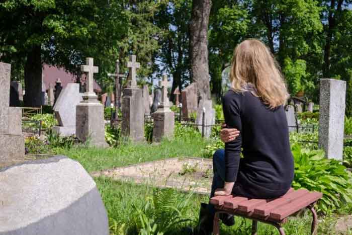 Женщина сидит на кладбище